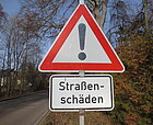 Verkehrszeichen Achtung - Ausrufezeichen mit roter Umrandung und Zusatzschild Straßenschäden