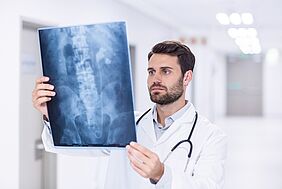 Junger Arzt betrachtet Röntgenbild