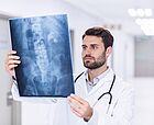 Junger Arzt betrachtet Röntgenbild