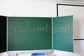 Eine Schultafel, auf die mit Kreise das Wort "Schulsozialarbeit" geschrieben wurde
