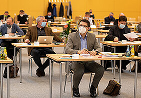 Kreisräte mit Mund-Nasenschutz im Sitzungssaal