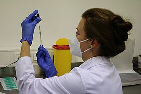 Ärztin bereitet eine Spritze für die Impfung vor