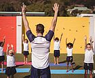 Trainer mit Kindern beim Yoga