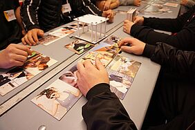 Fotokarten auf einem Tisch und Hände
