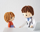Ein Arzt und ein Patient in Strickoptik dargestellt