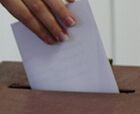 Wahlzettel wird in Wahlurne gesteckt