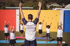 Trainer mit Kindern beim Yoga