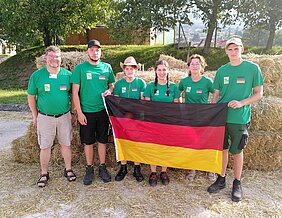 drei Männer und drei Frauen halten die Deutschland-Flagge